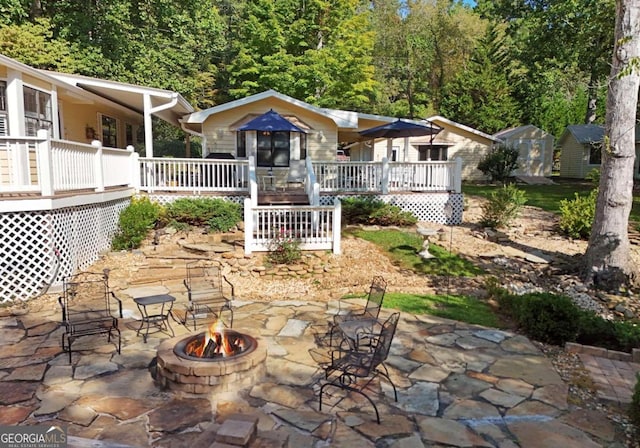 view of patio with a wooden deck and a fire pit