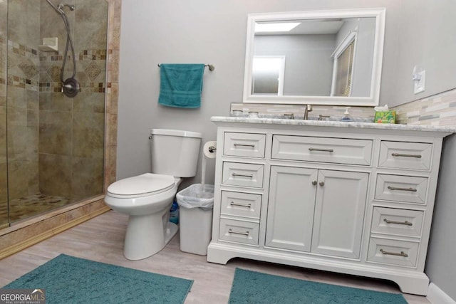 bathroom with hardwood / wood-style floors, vanity, decorative backsplash, toilet, and an enclosed shower