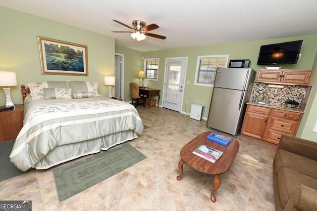 bedroom with ceiling fan and stainless steel refrigerator