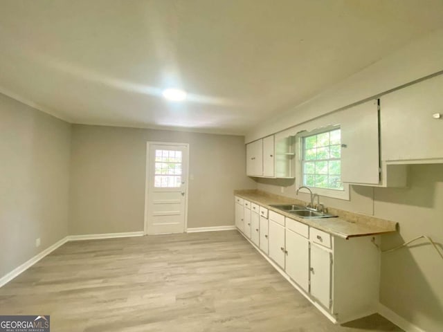 kitchen featuring sink, white cabinets, and light wood-type flooring