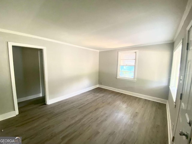 spare room featuring dark hardwood / wood-style floors and ornamental molding