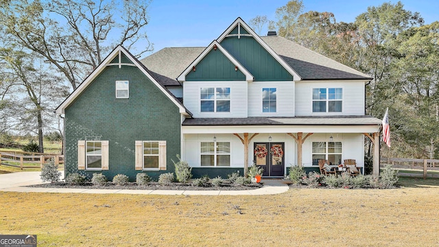 view of front of home featuring a front yard, french doors, and covered porch