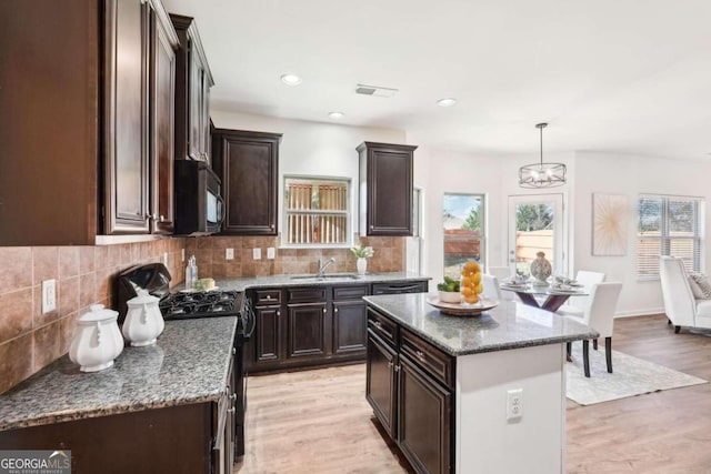 kitchen featuring a center island, light hardwood / wood-style floors, a healthy amount of sunlight, and sink