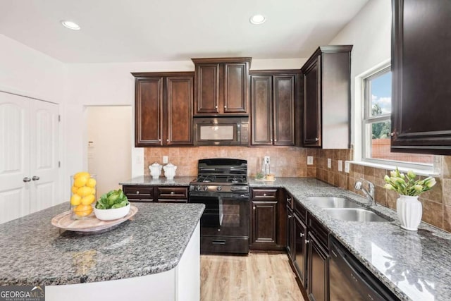 kitchen featuring sink, stone countertops, decorative backsplash, black appliances, and light wood-type flooring