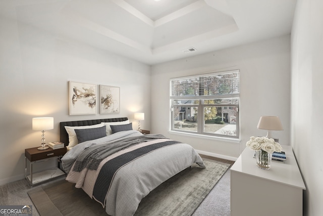 bedroom with carpet flooring and a raised ceiling