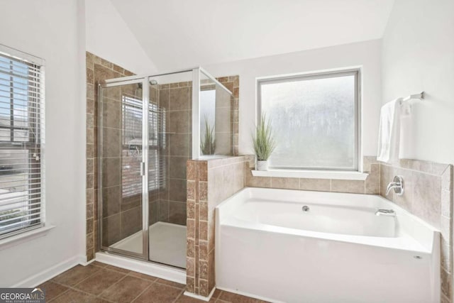 bathroom featuring tile patterned flooring, lofted ceiling, and shower with separate bathtub