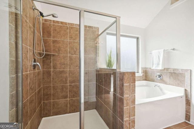 bathroom featuring tile patterned flooring, independent shower and bath, and lofted ceiling