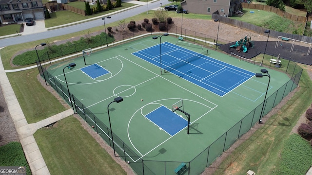 view of sport court featuring a playground and tennis court