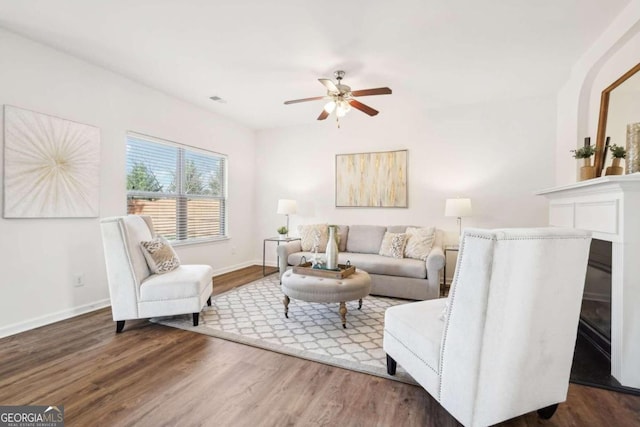 living room with ceiling fan and dark hardwood / wood-style flooring