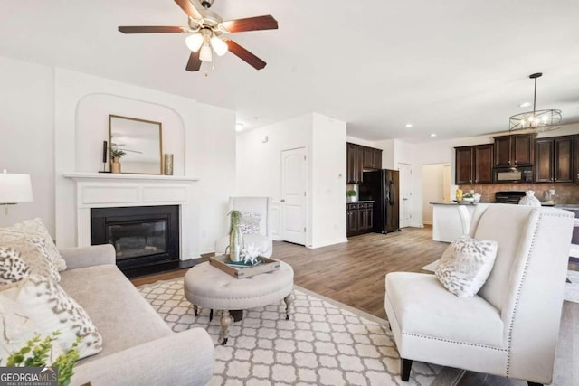 living room featuring ceiling fan and light wood-type flooring