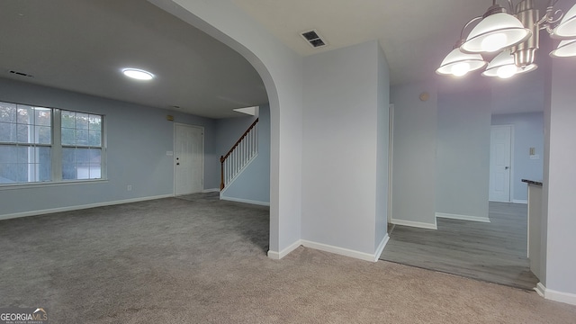 spare room with carpet floors and an inviting chandelier