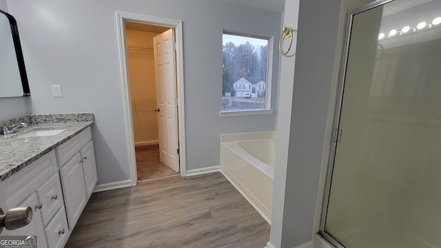 bathroom with vanity, independent shower and bath, and hardwood / wood-style flooring