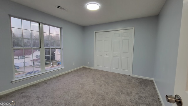 unfurnished bedroom featuring carpet floors and a closet