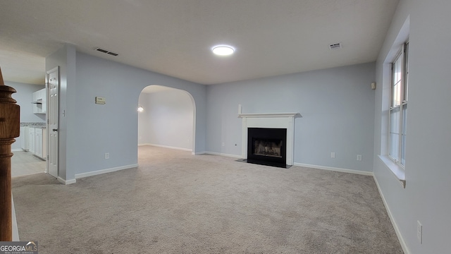 unfurnished living room featuring light carpet