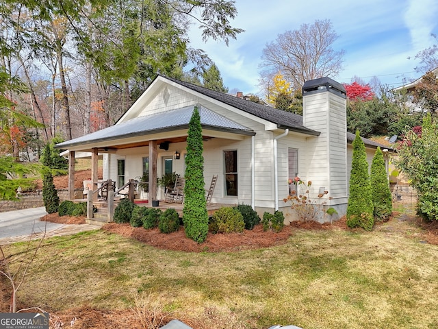 exterior space featuring covered porch and a front lawn