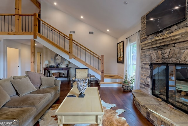 living room with dark wood-type flooring, a fireplace, and high vaulted ceiling