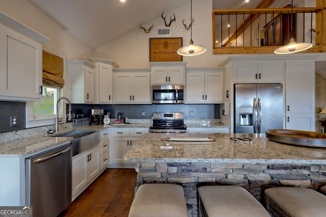 kitchen with hanging light fixtures, decorative backsplash, sink, and stainless steel appliances