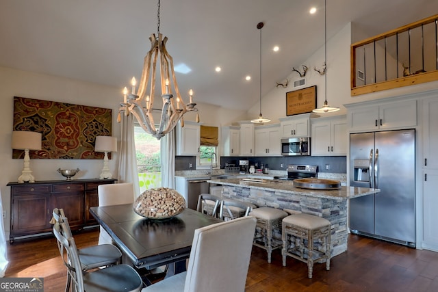 dining room with an inviting chandelier, dark hardwood / wood-style flooring, sink, and high vaulted ceiling