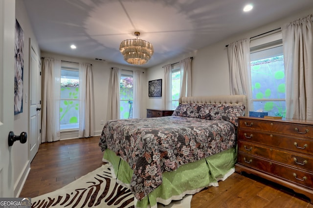 bedroom featuring dark hardwood / wood-style flooring and a chandelier