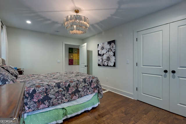 bedroom featuring a closet, dark wood-type flooring, and an inviting chandelier