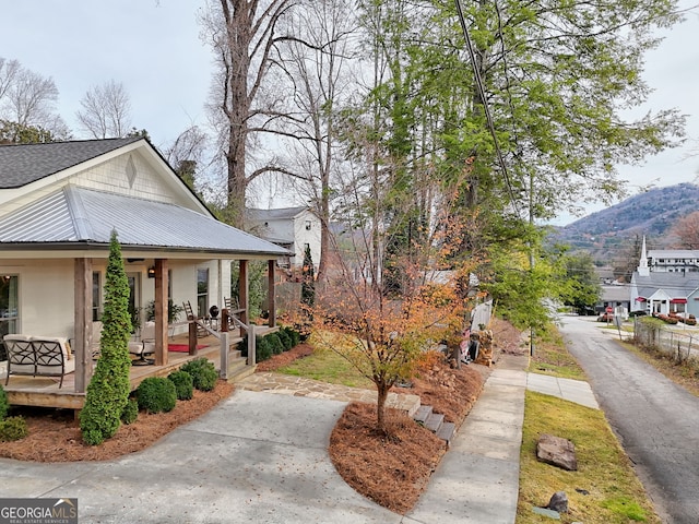 view of side of property featuring a mountain view and covered porch