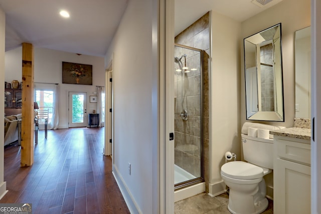 bathroom with an enclosed shower, vanity, wood-type flooring, and toilet