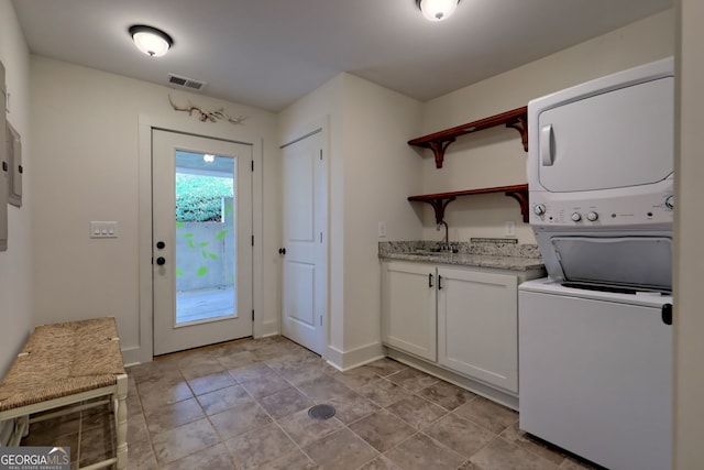 laundry area featuring sink and stacked washer and clothes dryer