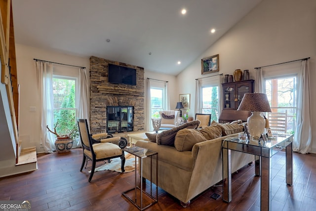 living room with high vaulted ceiling, a healthy amount of sunlight, a fireplace, and dark hardwood / wood-style flooring