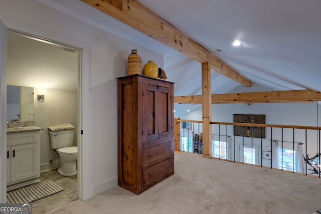 corridor featuring light colored carpet and lofted ceiling with beams