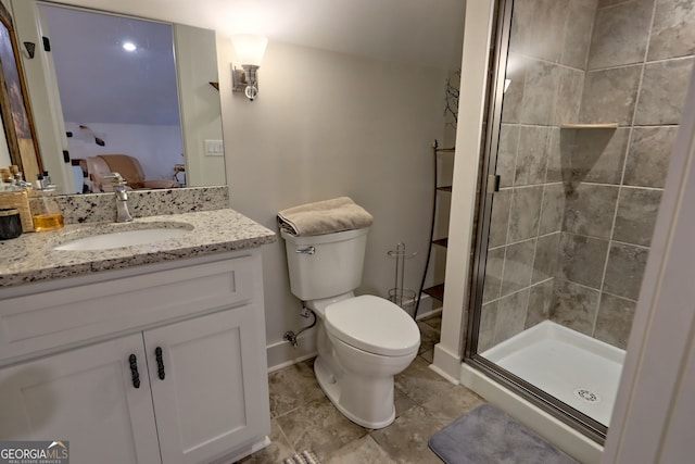 bathroom featuring toilet, a shower with shower door, and vanity