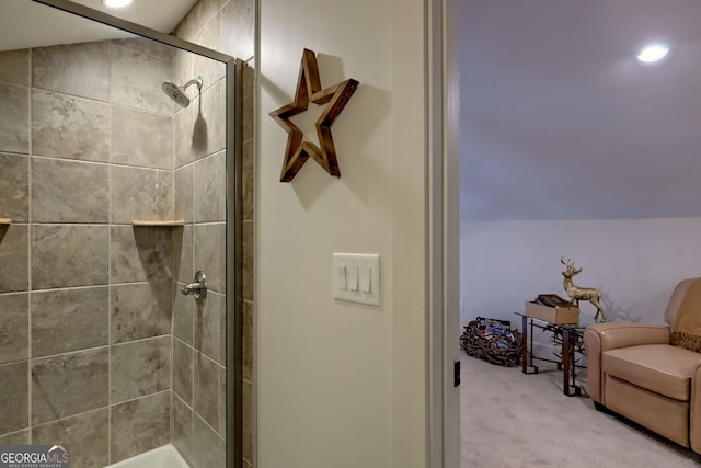 bathroom featuring a shower with door and vaulted ceiling