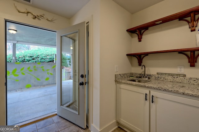 entryway featuring light tile patterned floors and sink