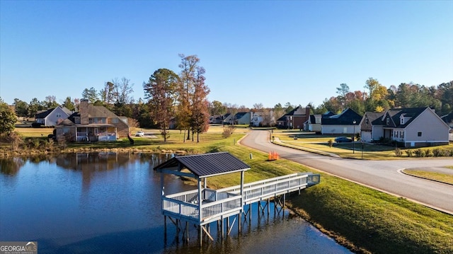 dock area with a water view and a yard