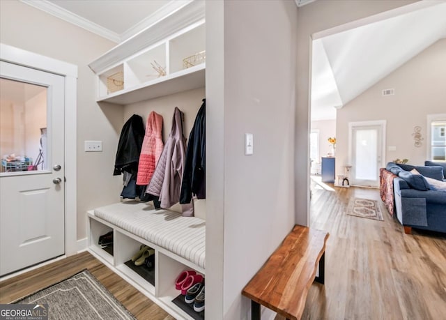 mudroom with wood-type flooring, ornamental molding, and lofted ceiling