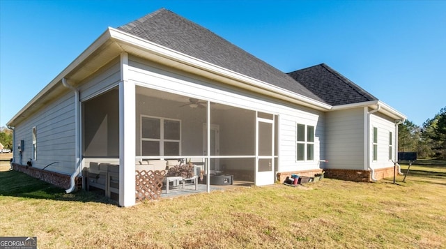 rear view of property with a lawn and a sunroom