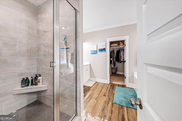 bathroom with vanity, ornamental molding, an enclosed shower, and hardwood / wood-style flooring