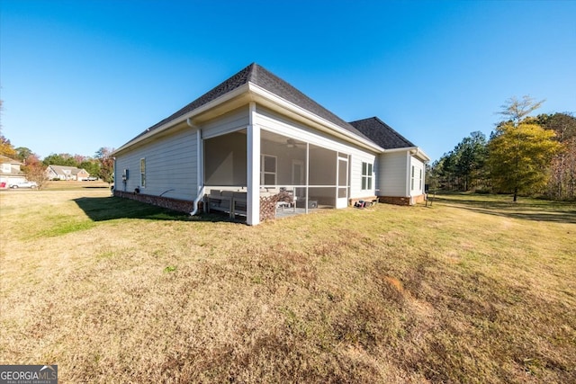 back of property with a lawn and a sunroom