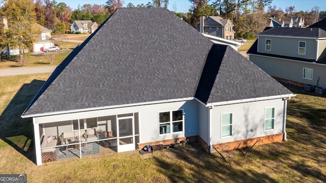 back of house with a lawn and a sunroom