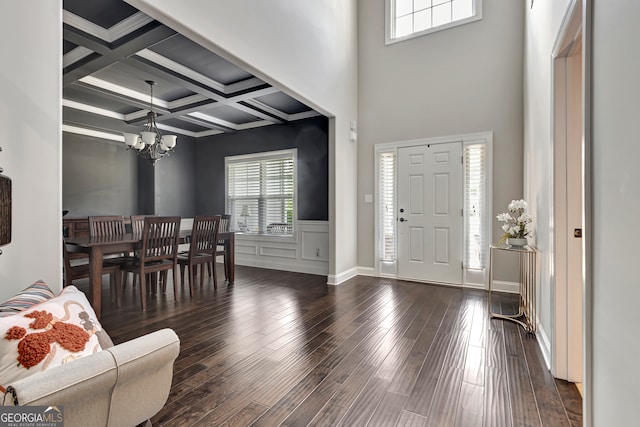 foyer featuring beamed ceiling, dark hardwood / wood-style flooring, coffered ceiling, and a notable chandelier