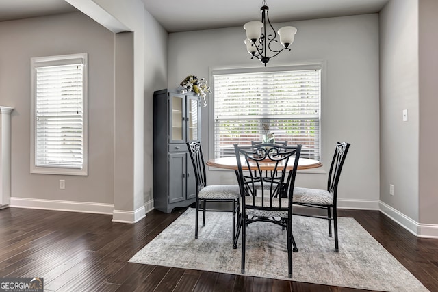 dining room with dark wood-type flooring and a notable chandelier