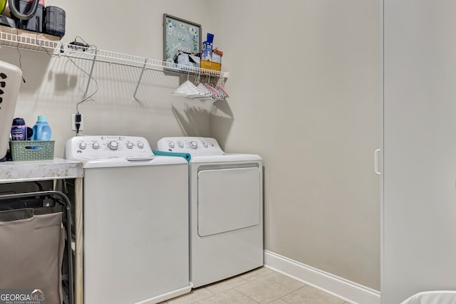 laundry room featuring washing machine and clothes dryer and light tile patterned flooring