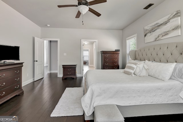 bedroom with dark hardwood / wood-style flooring, ensuite bathroom, and ceiling fan