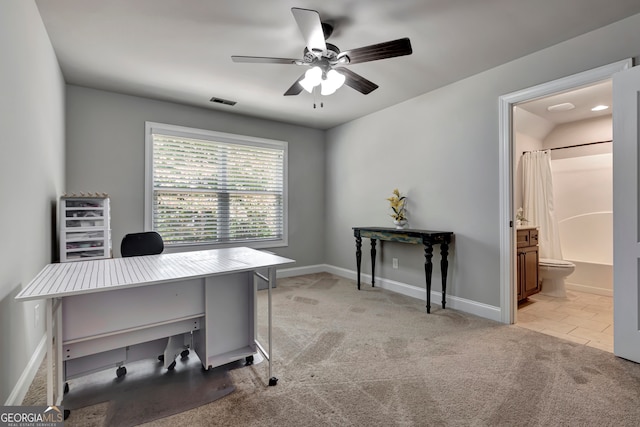 carpeted office space featuring ceiling fan