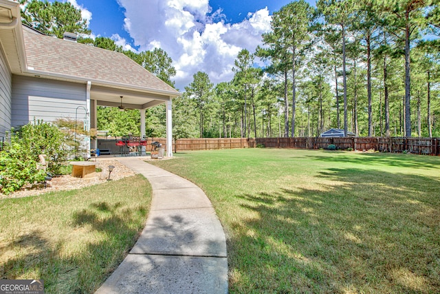 view of yard featuring ceiling fan and a patio area