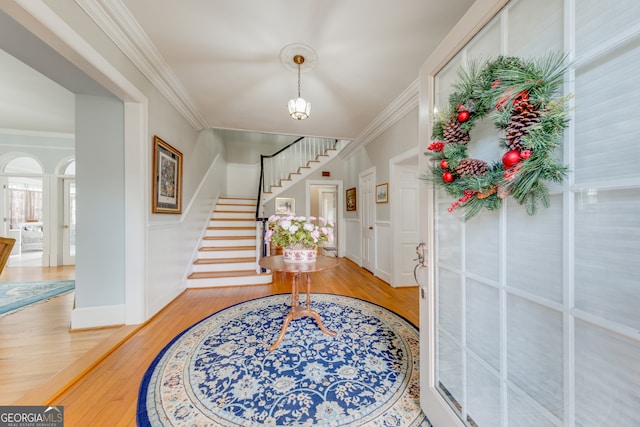 entrance foyer with hardwood / wood-style flooring and ornamental molding