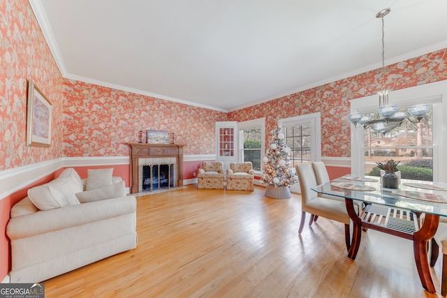 living room featuring a notable chandelier, wood-type flooring, and crown molding