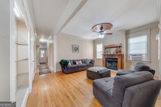 living room featuring light hardwood / wood-style flooring, ceiling fan, a healthy amount of sunlight, and crown molding