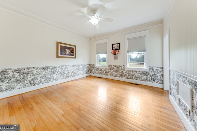 empty room featuring ceiling fan, light hardwood / wood-style floors, and ornamental molding