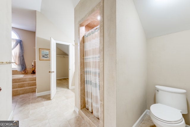 bathroom featuring toilet, curtained shower, and lofted ceiling