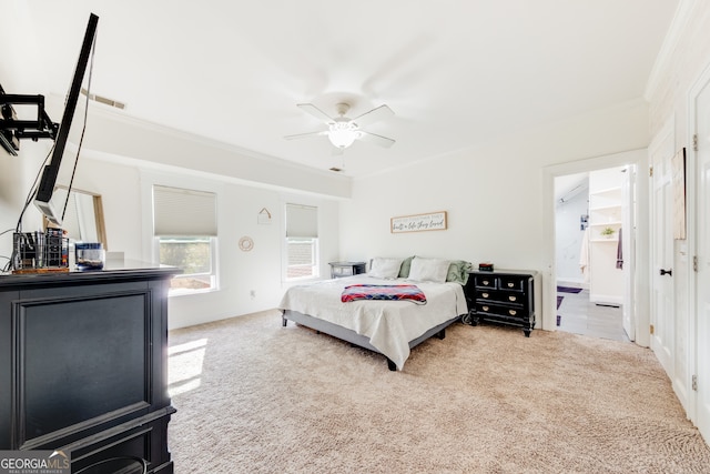 bedroom featuring ceiling fan, carpet floors, ornamental molding, and connected bathroom